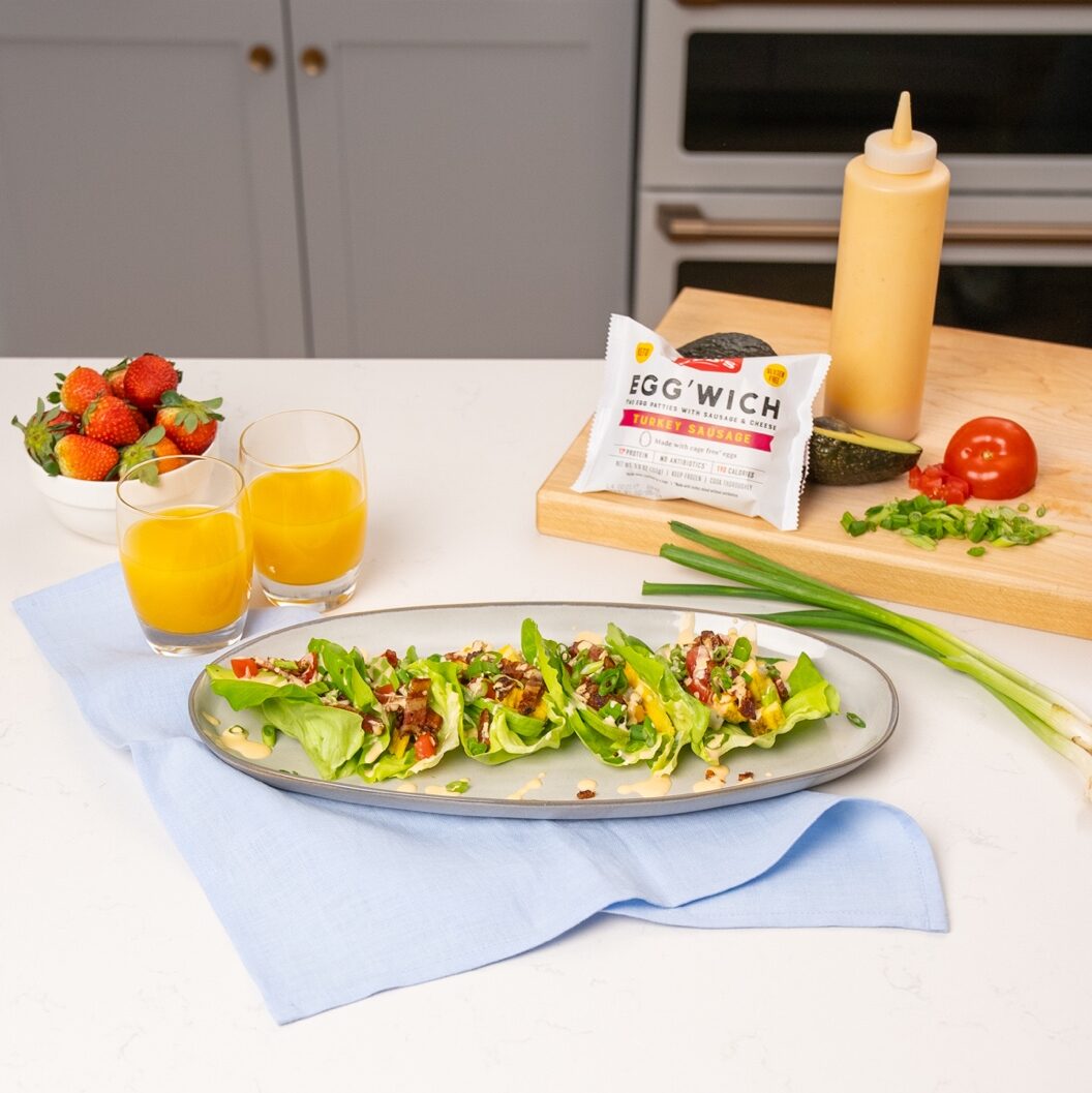 Egg'Wich Lettuce Wraps on counter with juice, fruit & ingredients